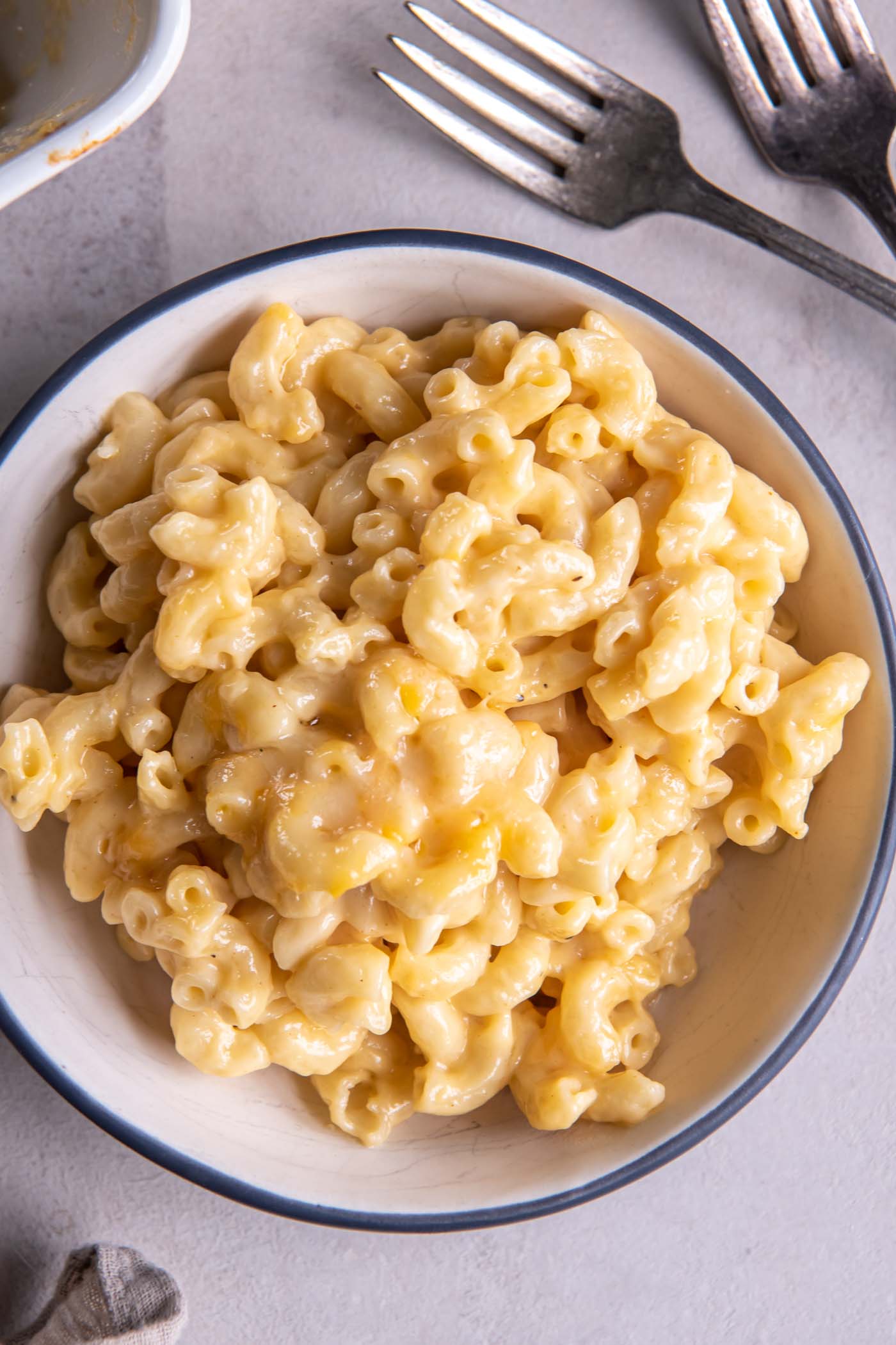 This Homemade Mac and Cheese Recipe is the best comfort food! This baked macaroni and cheese is exceptionally cheesy, creamy and so simple to make. Homemade mac and cheese served in a bowl.
